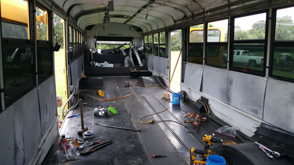 Skoolie build.  Removing school bus seats.